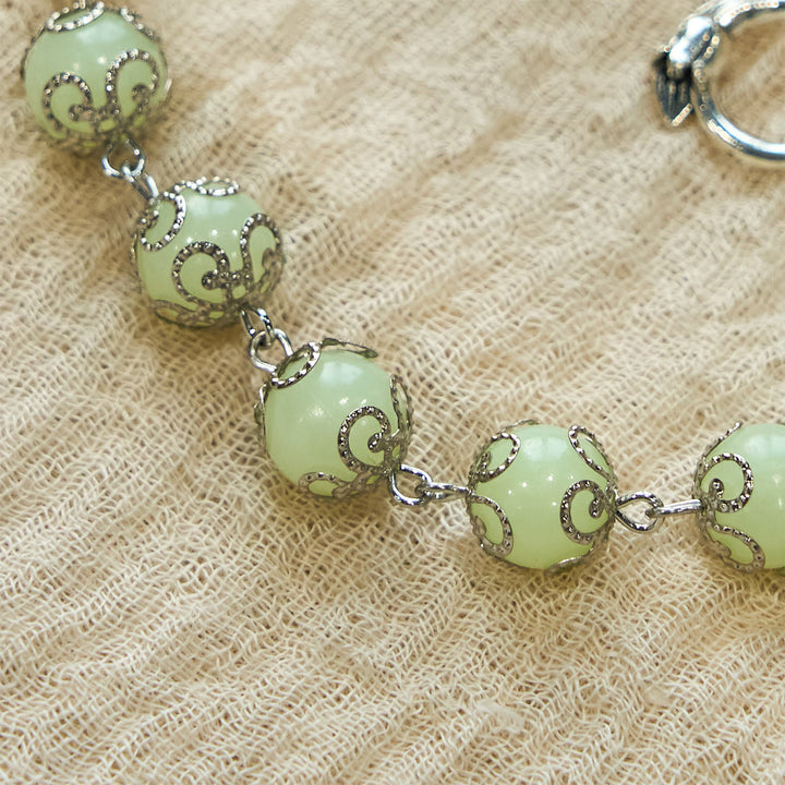 Bracelet lumineux crucifix rose en perles vertes de Christianartworkshop : Lumière onirique de la foi - image 4