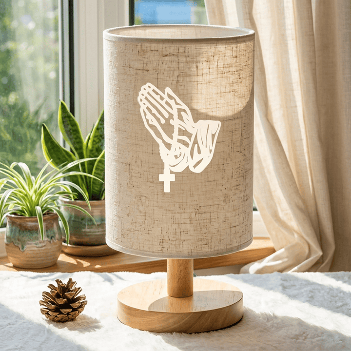Christianartworkshop Lampe de table avec pied en bois naturel, abat-jour en tissu et motif de mains jointes en croix : un symbole de calme et de sérénité nocturne. - image 3